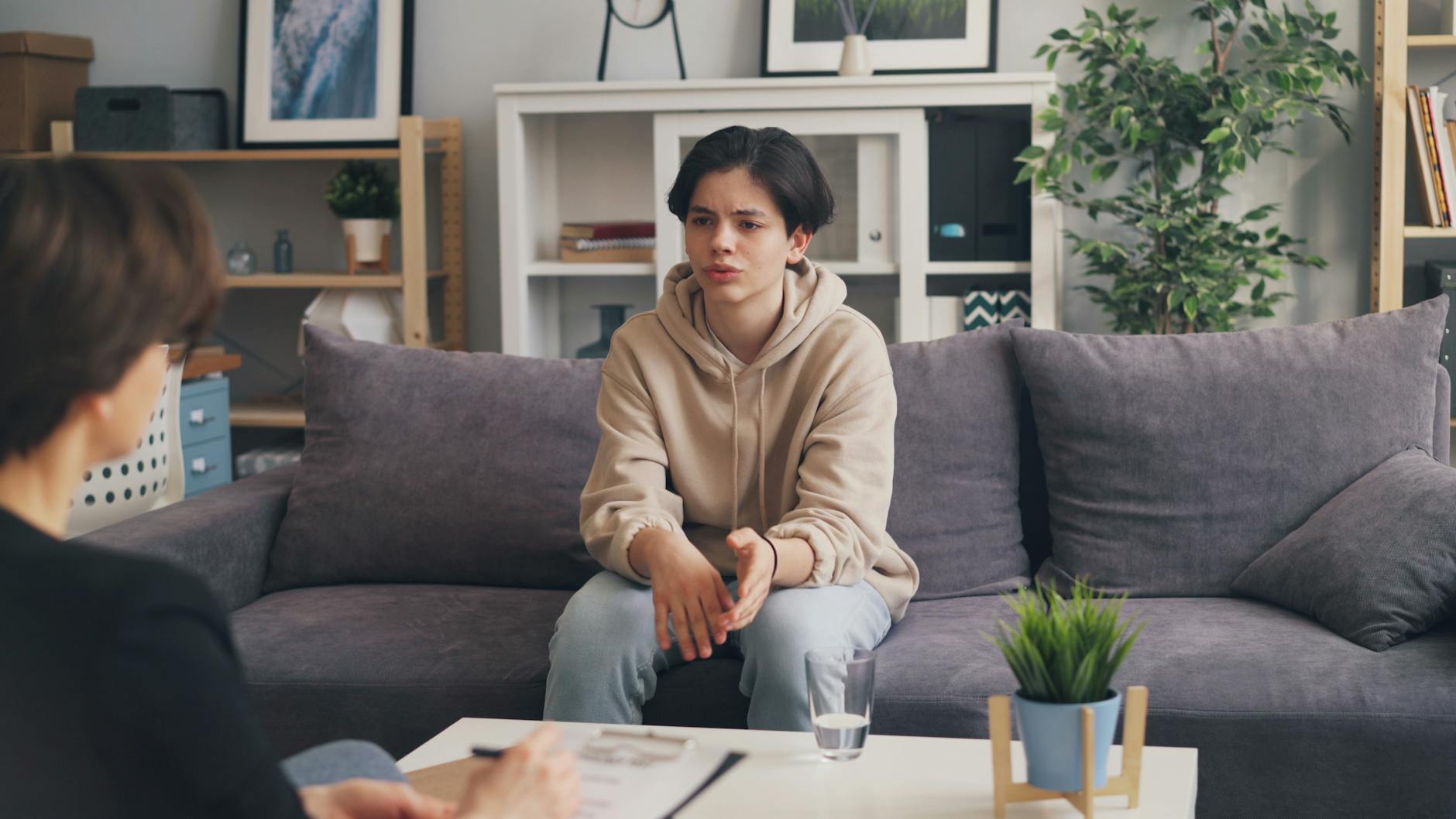 a woman sitting on a couch talking to a man